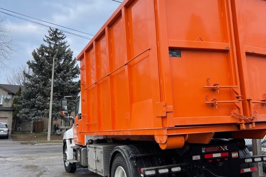 Image depicts an orange rental disposal bin from Bins Toronto