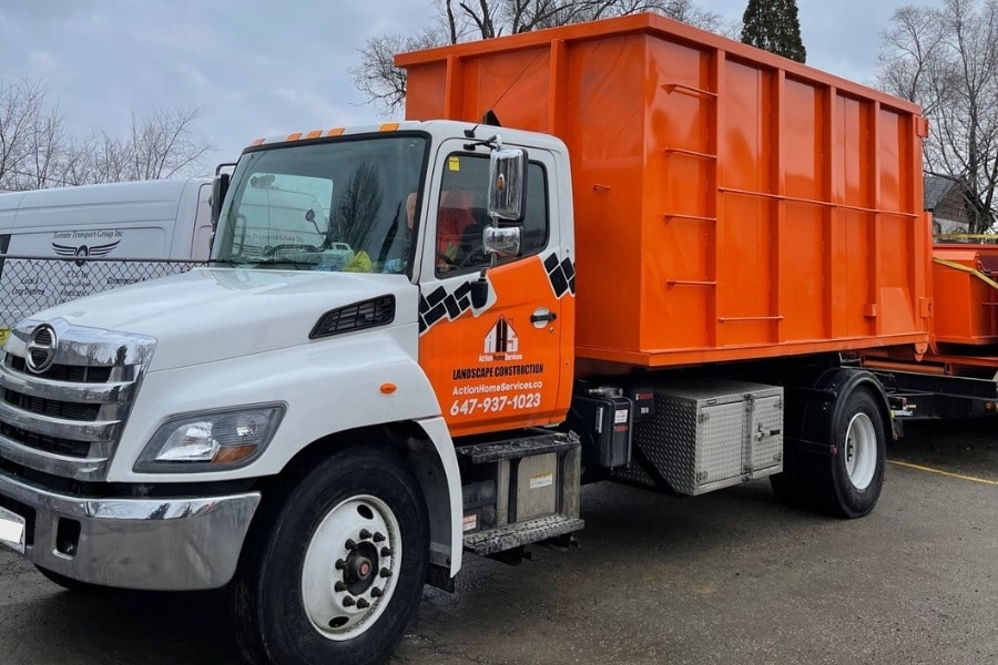 Image depicts Bins Toronto truck hauling a disposal bin.