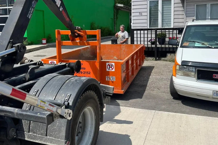 volunteers loading waste into dumpster gta