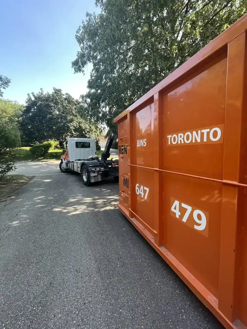 Commercial construction bin at a Toronto building site next to a residential dumpster