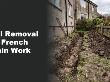 Excavated backyard trench with soil piled along a fence line during a French drain project